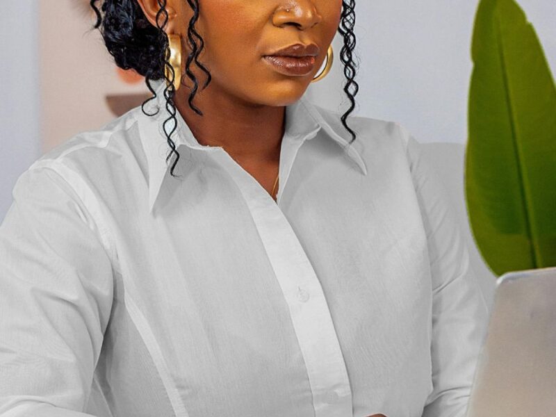 woman with braids wearing a whit shirt and working on a laptop how to style natural hair for an interview