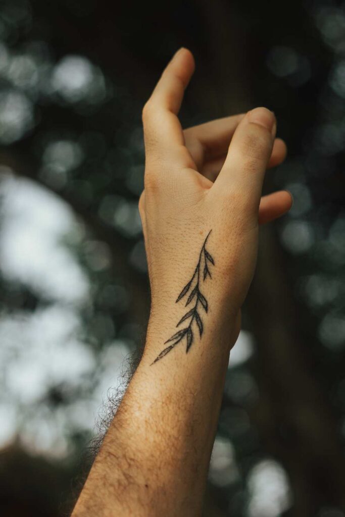 feather tattoo symbol /design  drew on a person hand
