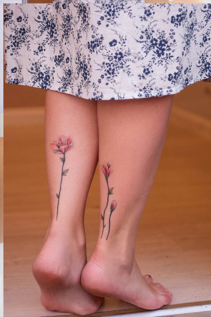 flowered designed tattoo on a woman's legs
