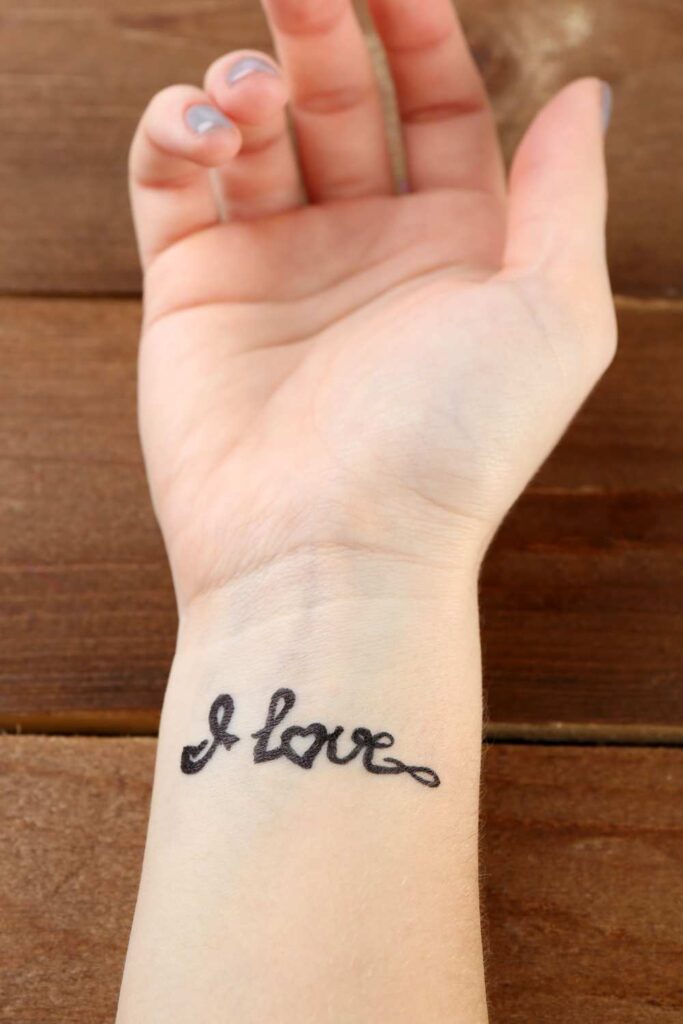 A scripted tattoo design saying I
 love