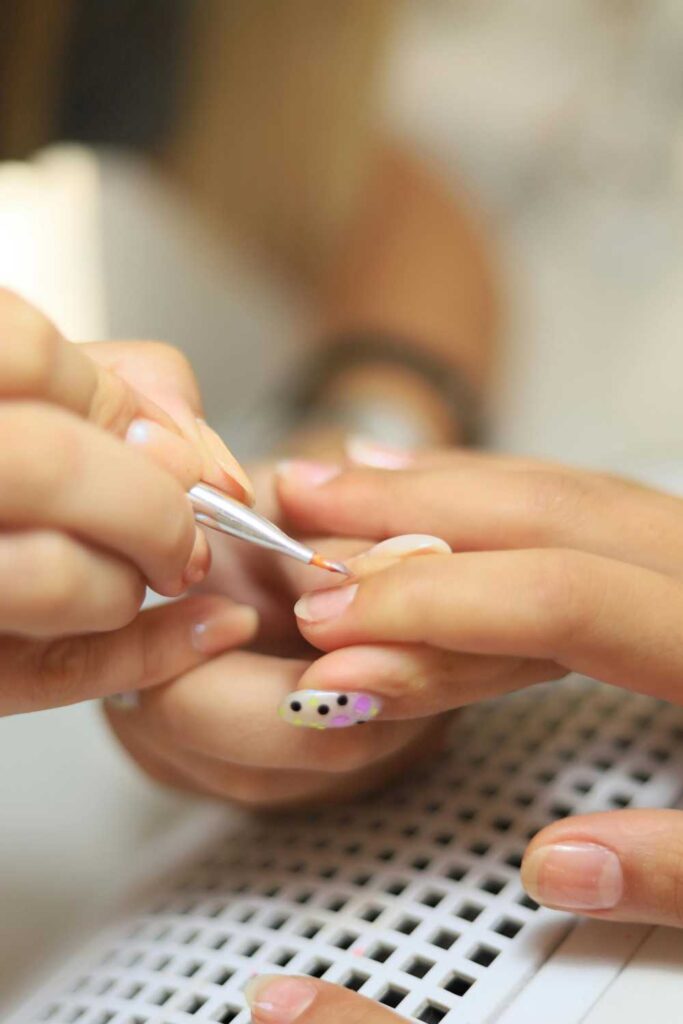 Someone shaping the finger nails of another to make it look healthy
