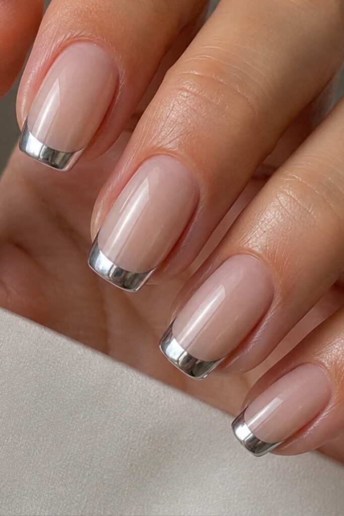 A picture of pink nude nails with a metal French tip