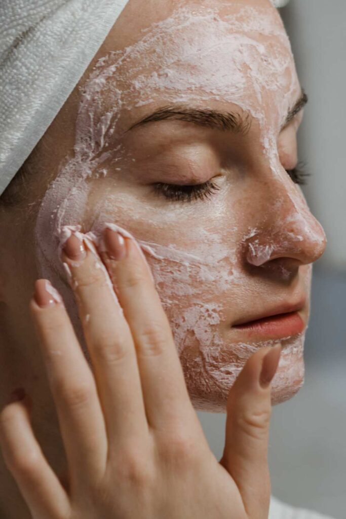 A picture of a lady exfoliating her face using scrub