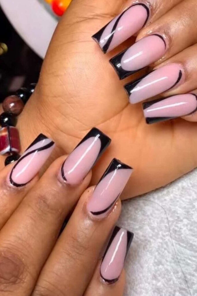 A gel nail polish of nude and black tips design