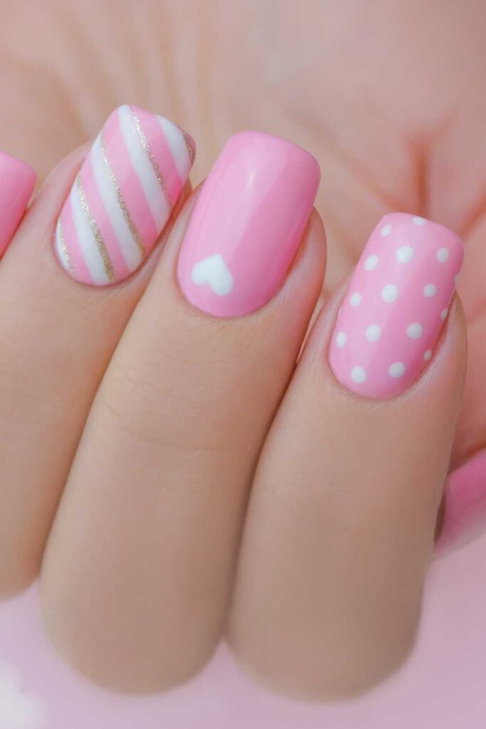 A picture of a heart designed pink nails.