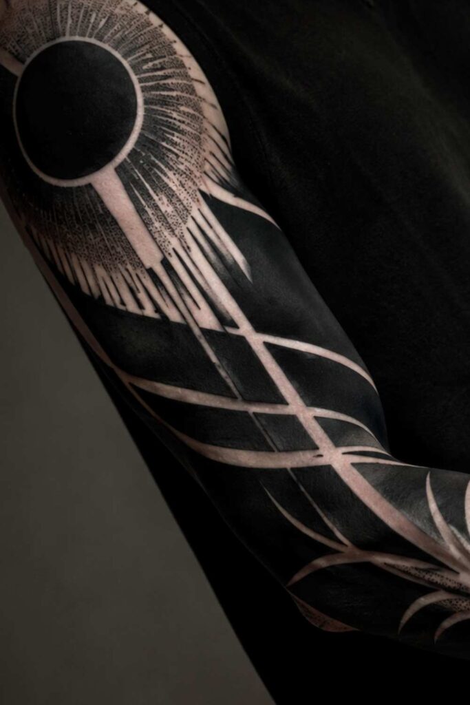 A blackwork- dark, graphic bold sleeve tattoo design.