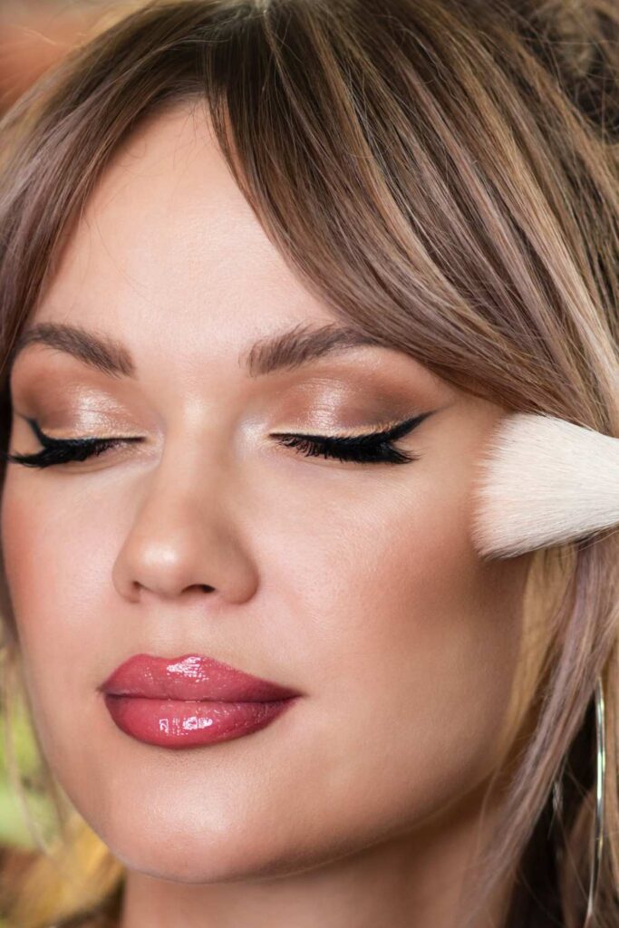 A lady applying bronzer using makeup brush